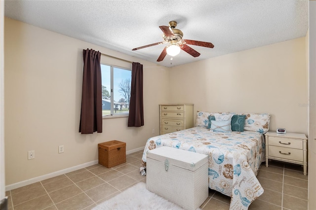 tiled bedroom featuring ceiling fan and a textured ceiling