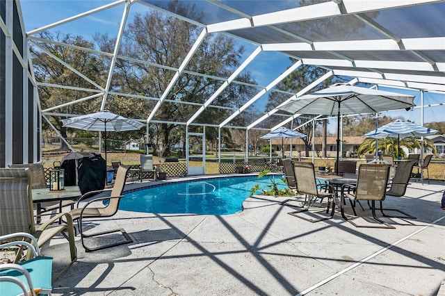 view of swimming pool with glass enclosure and a patio