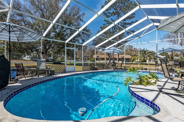 view of swimming pool featuring glass enclosure and a patio