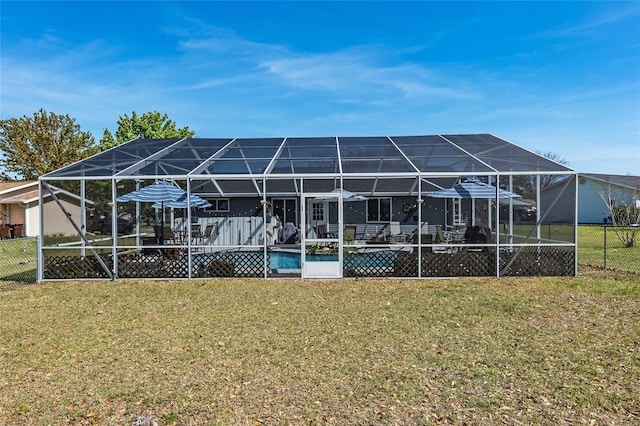 back of house featuring a lawn, a pool side deck, and glass enclosure