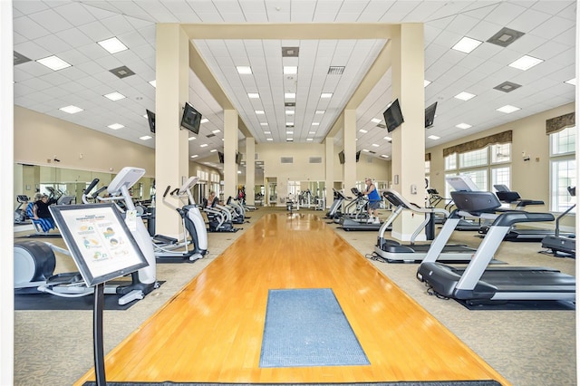 workout area with a drop ceiling and light wood-type flooring