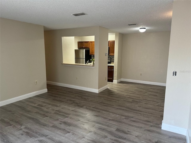 empty room with hardwood / wood-style floors and a textured ceiling