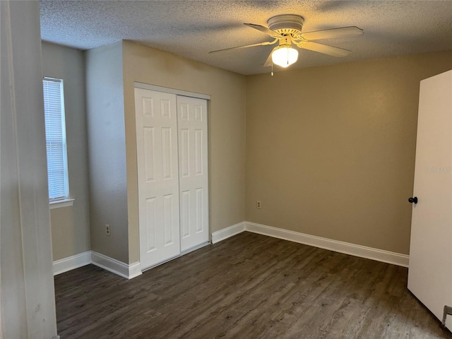 unfurnished bedroom featuring a textured ceiling, ceiling fan, dark wood-type flooring, and a closet