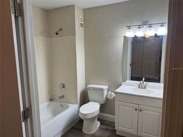 full bathroom with hardwood / wood-style flooring, tiled shower / bath combo, a textured ceiling, and vanity