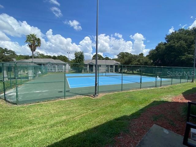 view of sport court with a yard