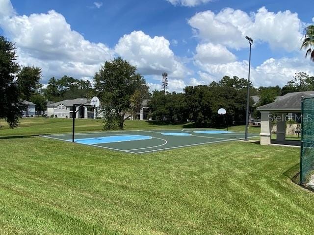 view of sport court featuring a yard