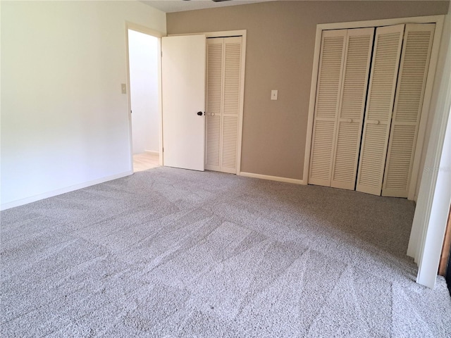 unfurnished bedroom featuring multiple closets and carpet