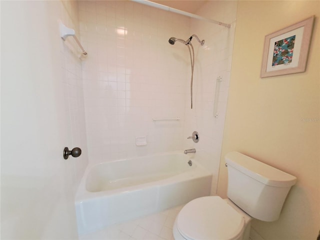 bathroom featuring tile patterned floors, toilet, and tiled shower / bath