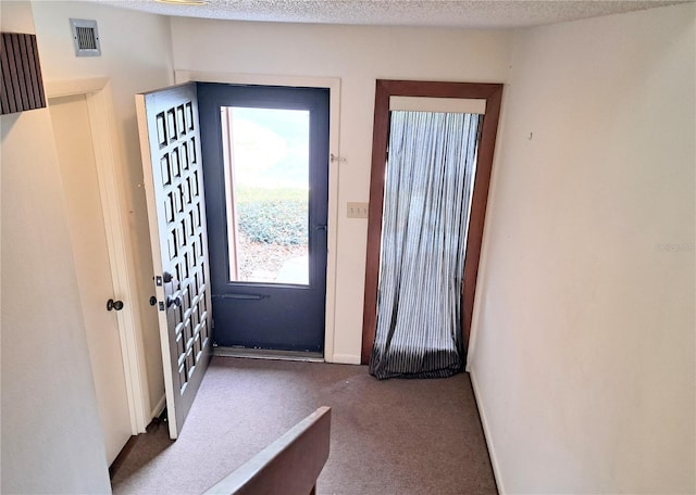 doorway to outside featuring a textured ceiling