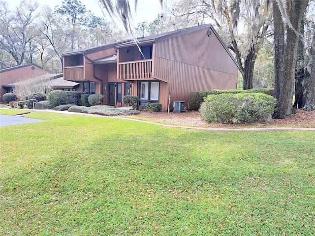 view of side of home featuring central AC and a lawn