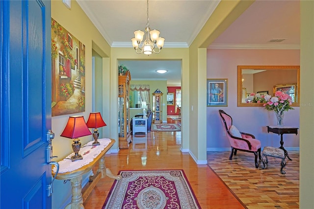 foyer with a notable chandelier, wood finished floors, visible vents, baseboards, and crown molding