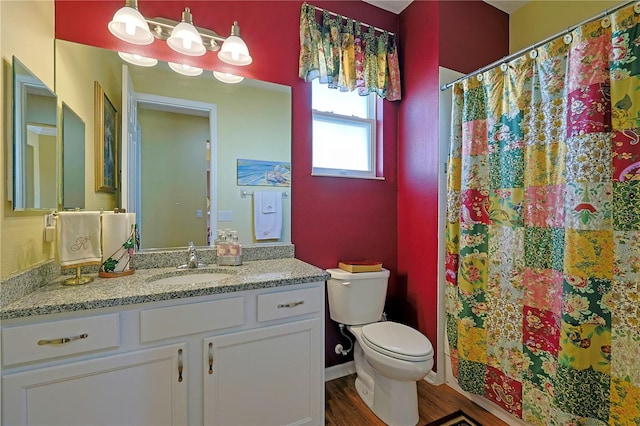 bathroom featuring toilet, a shower with curtain, wood finished floors, and vanity