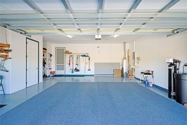 garage featuring water heater, electric panel, and a garage door opener