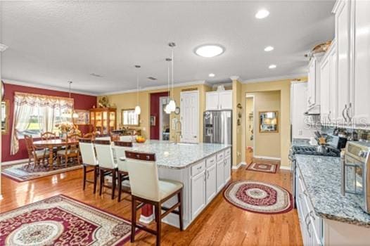 kitchen featuring stainless steel appliances, light wood finished floors, and white cabinetry