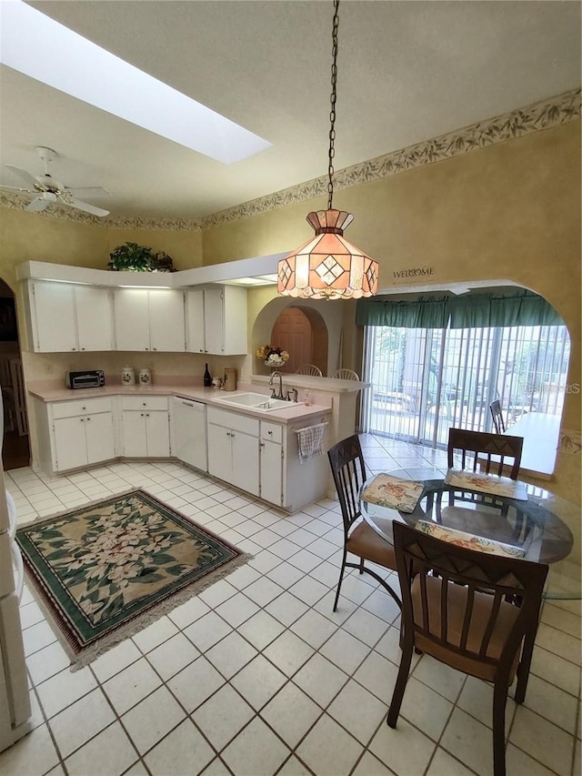 kitchen with white dishwasher, pendant lighting, ceiling fan, and white cabinetry