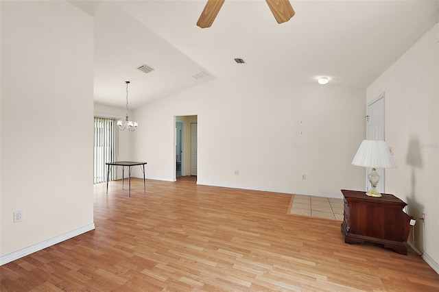 living room featuring ceiling fan with notable chandelier, light hardwood / wood-style flooring, and vaulted ceiling