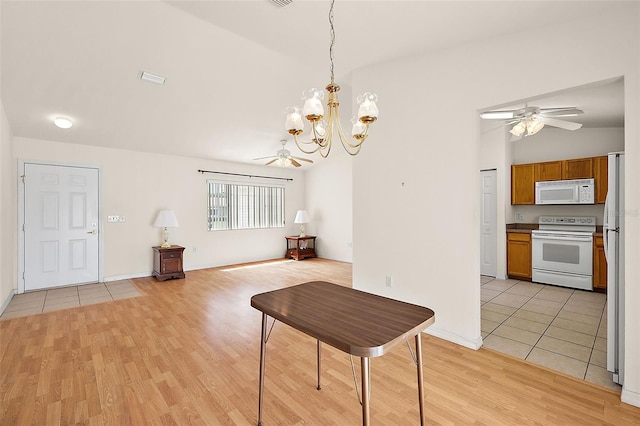 dining area with ceiling fan with notable chandelier, light hardwood / wood-style floors, and vaulted ceiling