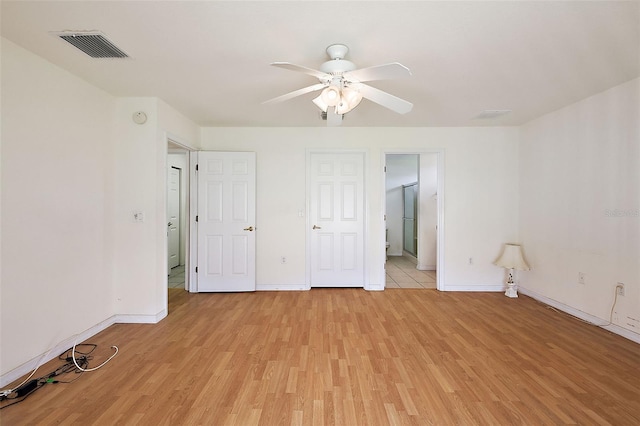 unfurnished bedroom featuring ceiling fan, light wood-type flooring, and ensuite bathroom