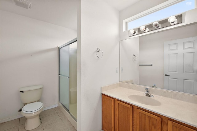 bathroom featuring tile patterned floors, vanity, a shower with shower door, and toilet