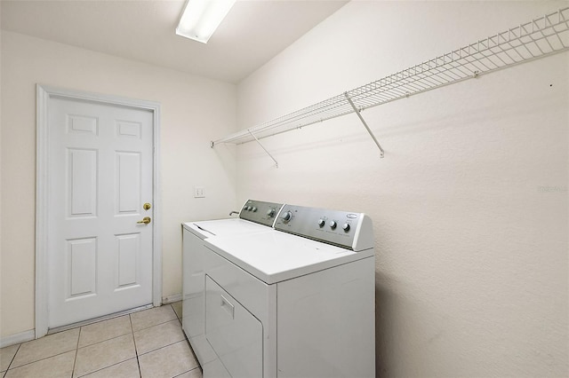 laundry area featuring washer and dryer and light tile patterned flooring