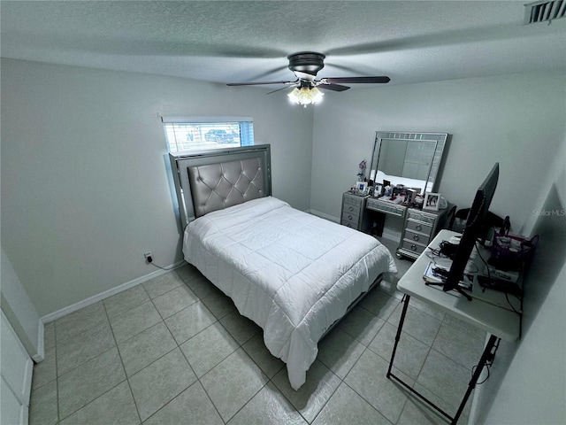 bedroom featuring a textured ceiling, light tile patterned floors, and ceiling fan