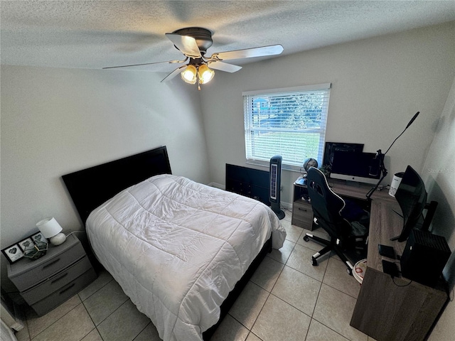 tiled bedroom with ceiling fan and a textured ceiling