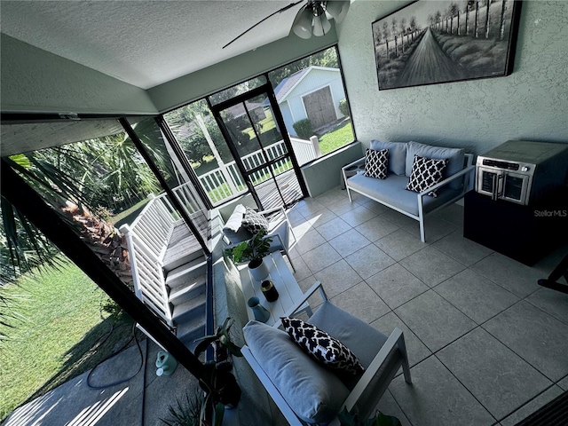 living room with a textured ceiling, tile patterned floors, and ceiling fan