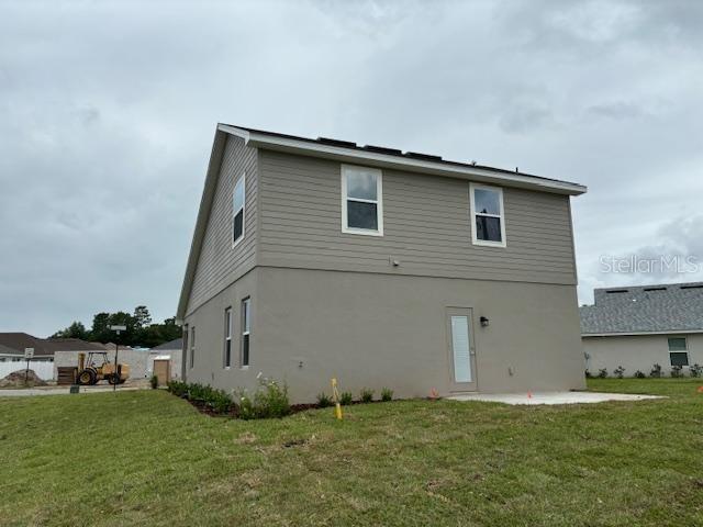 rear view of house featuring a yard and a patio area