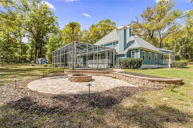 back of house with a fire pit, a lanai, a yard, and a patio