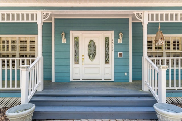 view of exterior entry featuring covered porch