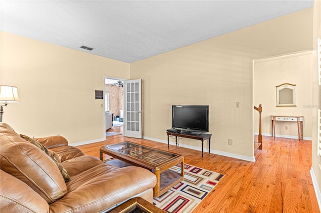 living room featuring ceiling fan and light hardwood / wood-style floors