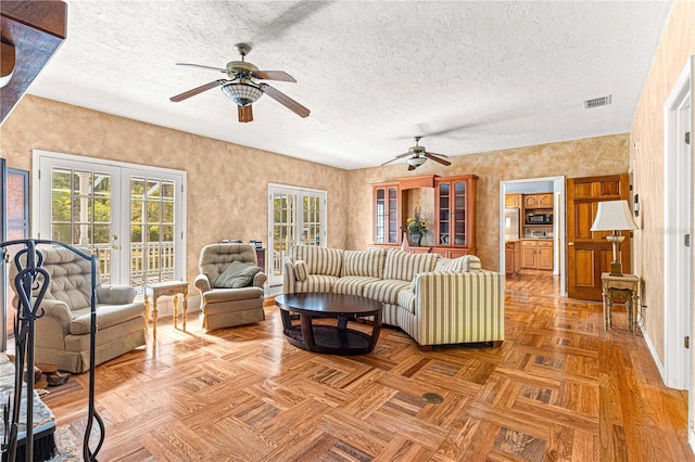 living room featuring parquet flooring, french doors, a textured ceiling, and ceiling fan