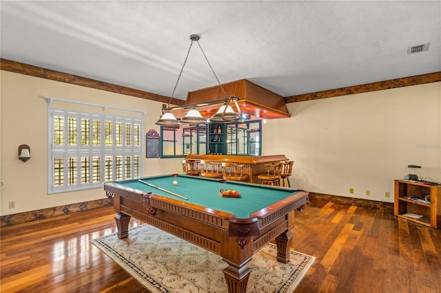 game room featuring bar, wood-type flooring, a textured ceiling, and pool table