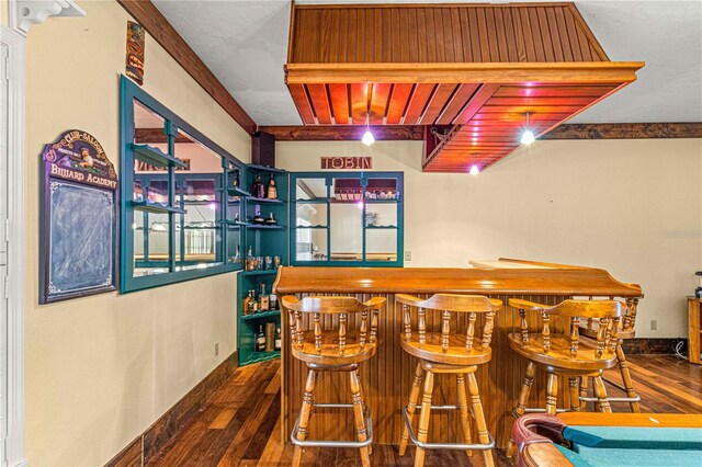 bar with beam ceiling and dark wood-type flooring