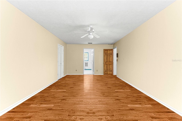 empty room with hardwood / wood-style floors and ceiling fan