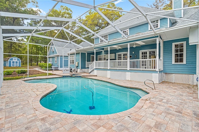 view of pool with a storage shed, a patio, ceiling fan, and a lanai