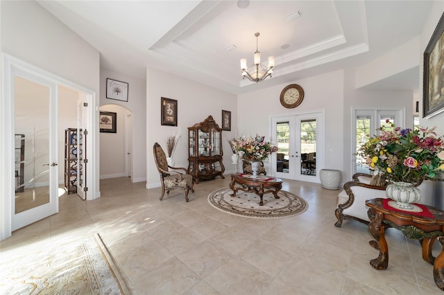 sitting room featuring light tile floors, french doors, a notable chandelier, and a tray ceiling