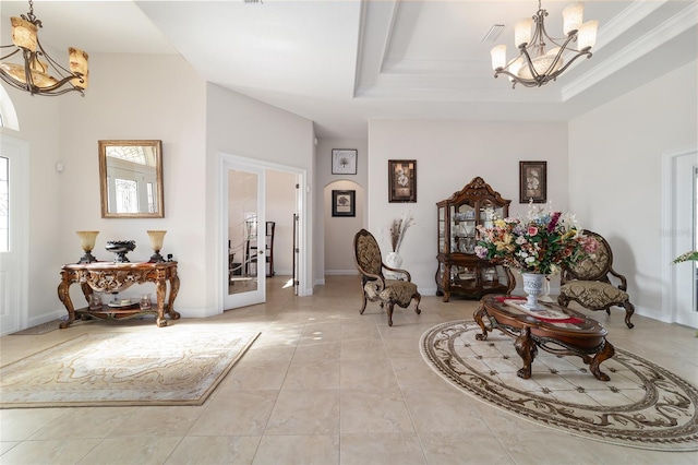 living area featuring a chandelier, light tile flooring, and a raised ceiling