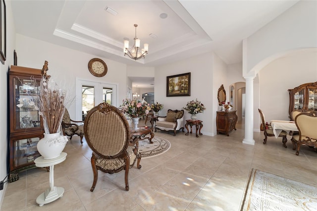 tiled dining space featuring a chandelier, a raised ceiling, decorative columns, and french doors