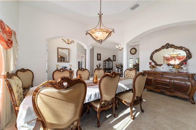 dining space with an inviting chandelier, ornate columns, and light tile floors