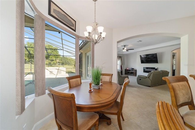 tiled dining area with ceiling fan with notable chandelier