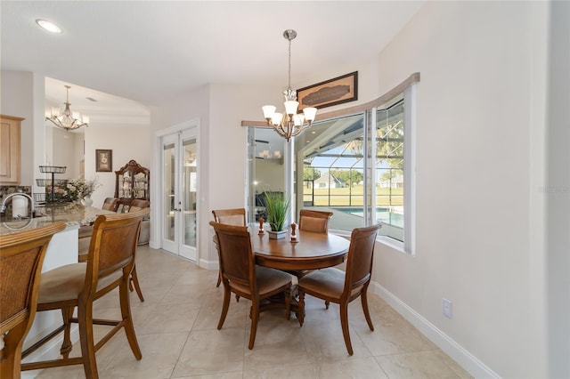 tiled dining room featuring french doors, an inviting chandelier, and sink