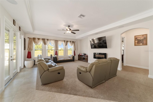 living room with light tile floors, ceiling fan, a tray ceiling, and french doors