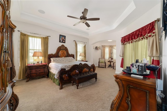 carpeted bedroom with a tray ceiling and ceiling fan