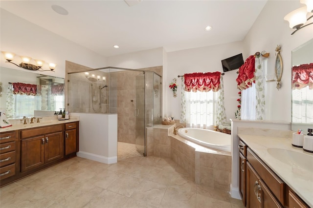 bathroom with tile floors, vanity with extensive cabinet space, and separate shower and tub