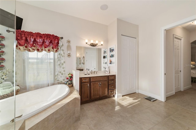 bathroom with vanity, tile flooring, and tiled tub