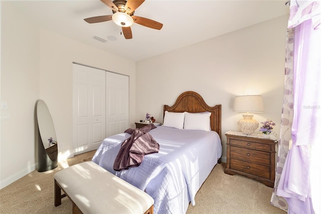 bedroom featuring a closet, ceiling fan, and light colored carpet