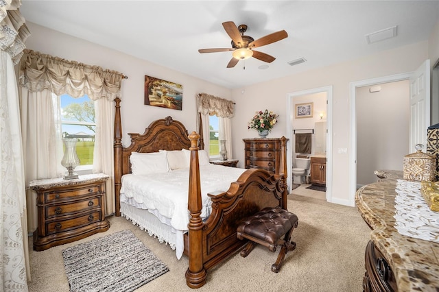 carpeted bedroom with multiple windows, ensuite bath, and ceiling fan