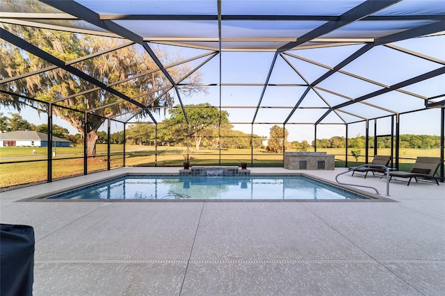 view of pool with an in ground hot tub, a yard, glass enclosure, and a patio area