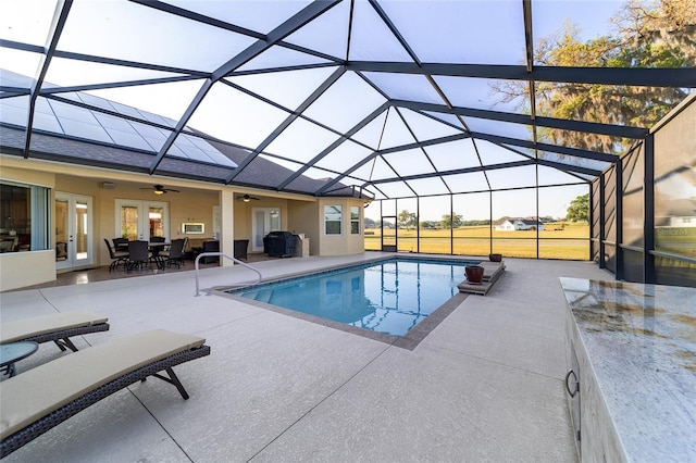 view of pool with a patio area, ceiling fan, french doors, and glass enclosure